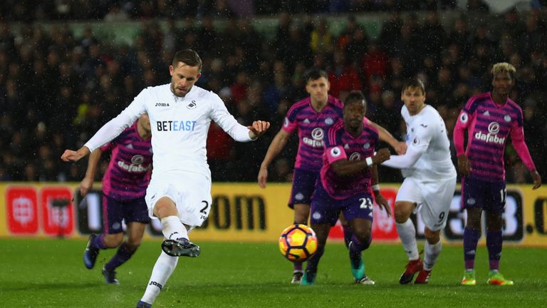SWANSEA, WALES - DECEMBER 10: Gylfi Sigurdsson of Swansea City (L) scores his sides first goal from the penalty spot during the Premier League match betwee