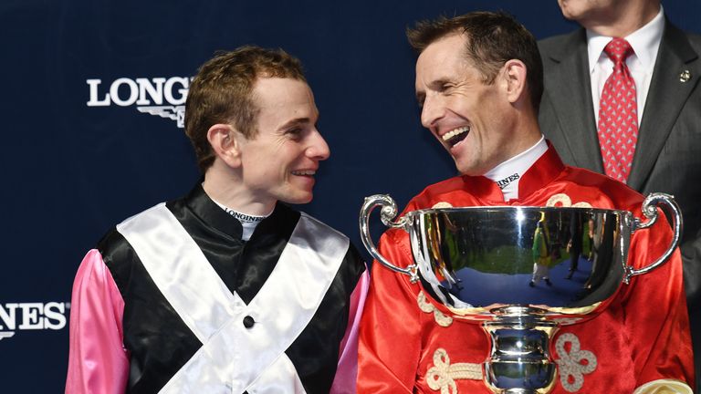 Hugh Bowman of Australia poses with the winning trophy for the International Jockeys' Challenge and smiles at runner-up Ryan Moore of the UK.