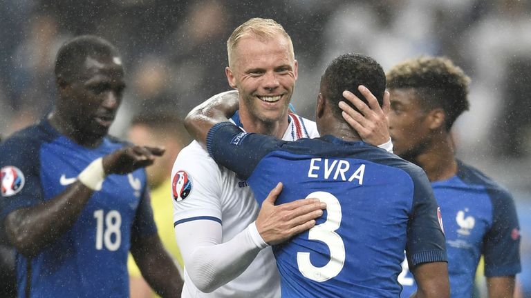 Iceland's forward Eidur Gudjohnsen (L) congratulates France's defender Patrice Evra after the Euro 2016 quarter-final football match between France and Ice