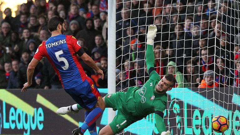 Crystal Palace's English defender James Tomkins (L) shoots past Southampton's English goalkeeper Fraser Forster to scores his team's second goal during the