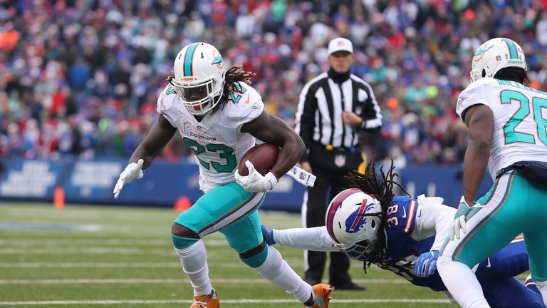 ORCHARD PARK, NY - DECEMBER 24:  Jay Ajayi #23 of the Miami Dolphins slips a tackle by Sergio Brown #38 of the Buffalo Bills scores a touchdown against the