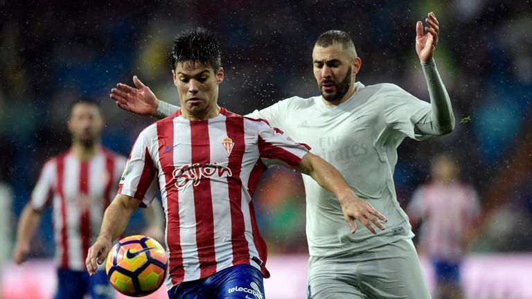 Sporting Gijon's defender Jorge Mere (L) vies with Real Madrid's French forward Karim Benzema during the Spanish league football match Real Madrid CF vs Re