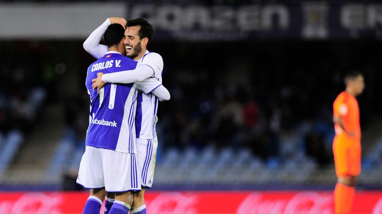 Real Sociedad's midfielder Juanmi (R) is congratulated by teammate Mexican forward Carlos Vela (L) after scoring his team's third goal during the Spanish l