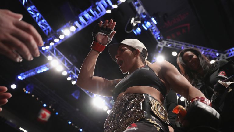 Nunes celebrates her UFC title in the Octagon