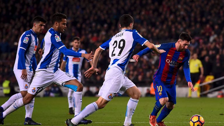 Barcelona's Argentinian forward Lionel Messi (R) vies with Espanyol's defender Aaron Caricol (2R) and Espanyol's defender Diego Reyes (2L) during the Spani