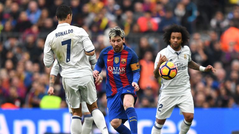 BARCELONA, SPAIN - DECEMBER 03: Lionel Messi of Barcelona and Cristiano Ronaldo of Real Madrid compete for the ball during the La Liga  match between FC Ba