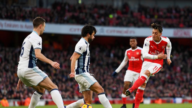 Mesut Ozil (R) has a shot blocked by Claudio Yacob (C) 