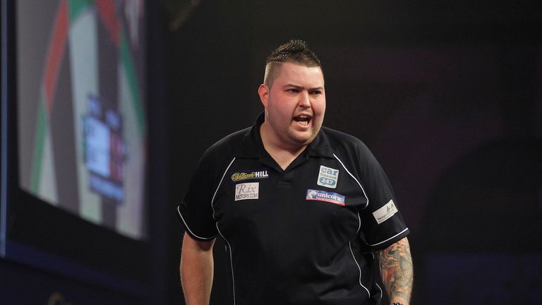 Michael Smith celebrates his victory in round one (Picture: Lawrence Lustig)