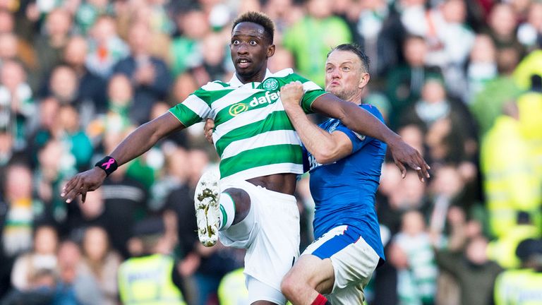 Rangers defender Clint Hill (R) grapples with Moussa Dembele of Celtic