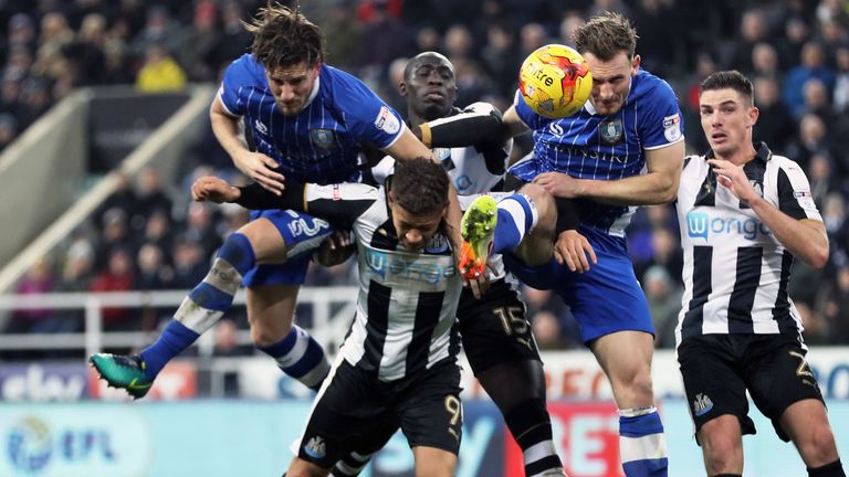 Newcastle United's Dwight Gayle (no. 9) battles for the ball