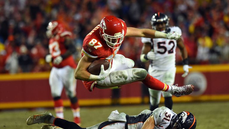 KANSAS CITY, MO - DECEMBER 25:  Tight end Travis Kelce #87 of the Kansas City Chiefs leaps over free safety Justin Simmons #31 of the Denver Broncos during