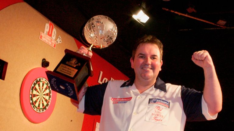 Phil Taylor of England poses with the trophy after beating Peter Manley