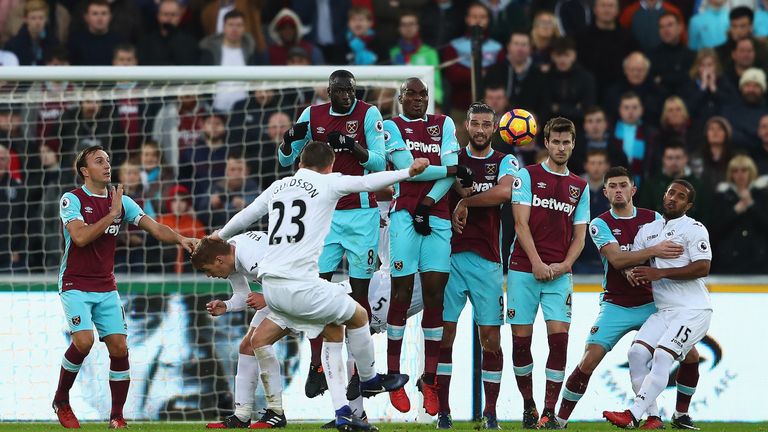 Gylfi Sigurdsson strikes a free kick over a wall of West Ham players