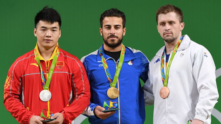 Iran's gold medallist Kianoush Rostami (C), China's silver medallist (L) Tian Tao and Romania's bronze medallist Gabriel Sincraian pose on the podium after