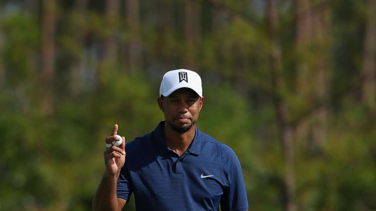 Tiger Woods acknowledges the crowd after tapping in for birdie at the 12th