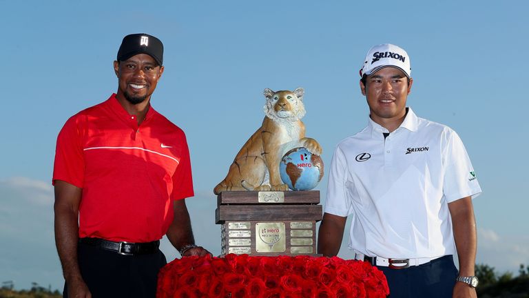 Hideki Matsuyama receives the trophy from tournament host Tiger Woods after winning the Hero World Challenge at Albany