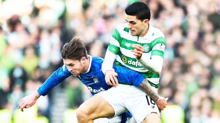 Josh Windass of Rangers (L) and Celtic midfielder Tom Rogic challenge for the ball
