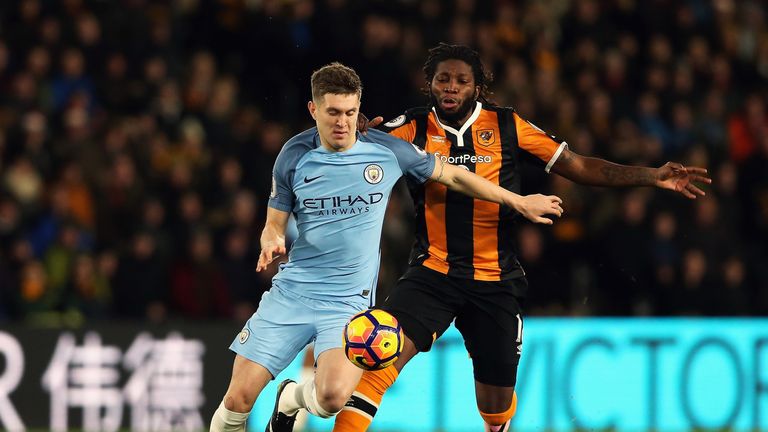 Dieumerci Mbokani of Hull City challenges John Stones of Manchester City during the Premier League match at the Etihad