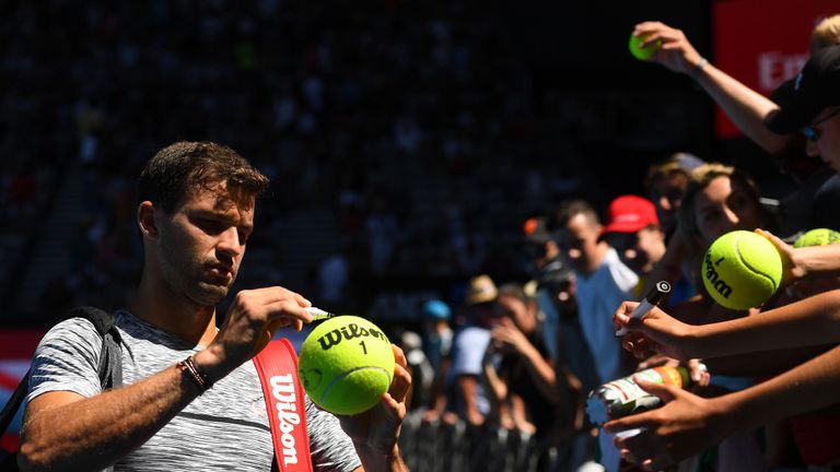 Grigor Dimitrov signs autographs for fans after winning his second round match against Hyeon Chung