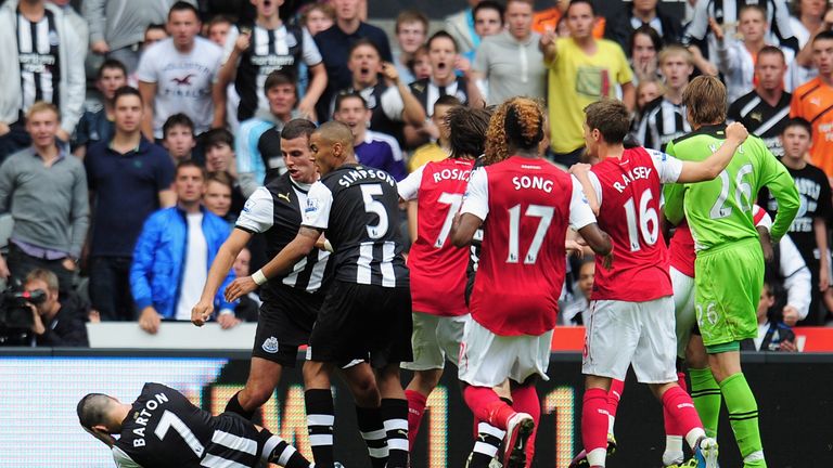 Joey Barton of Newcastle goes to ground clutching his head after a clash with Gervinho of Arsenal in 2011