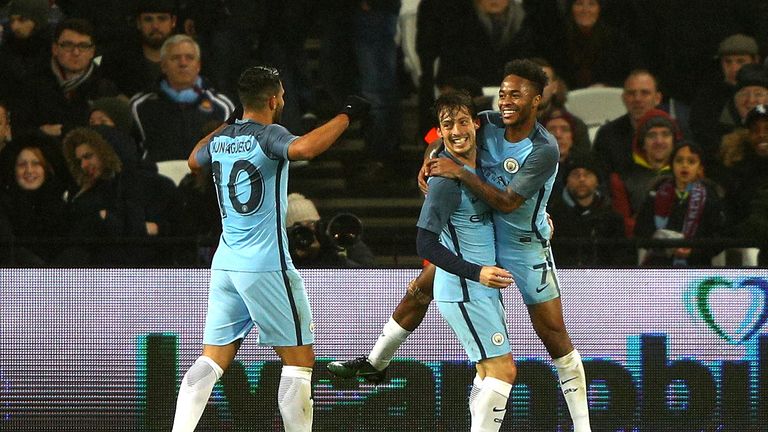 LONDON, ENGLAND - JANUARY 06:  David Silva of Manchester City celebrates scoring his sides third goal with Raheem Sterling of Manchester City during The Em