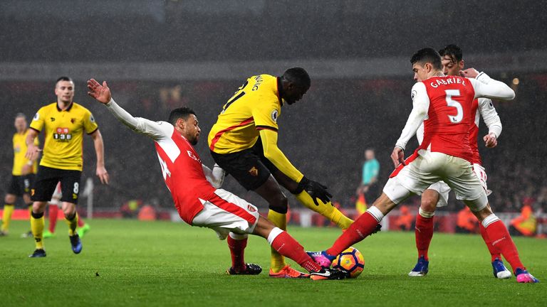 LONDON, ENGLAND - JANUARY 31: M'Baye Niang (C) of Watford competes for the ball against Francis Coquelin (L) and Gabriel (R) of Arsenal during the Premier 