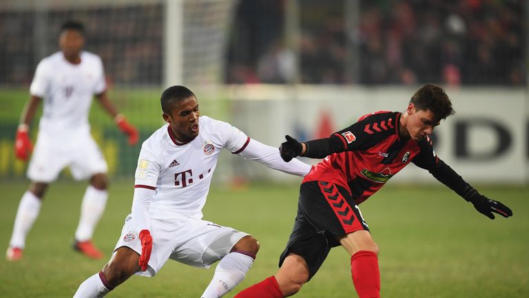 Douglas Costa of Bayern Munich is challenged by Pascal Stenzel of Freiburg