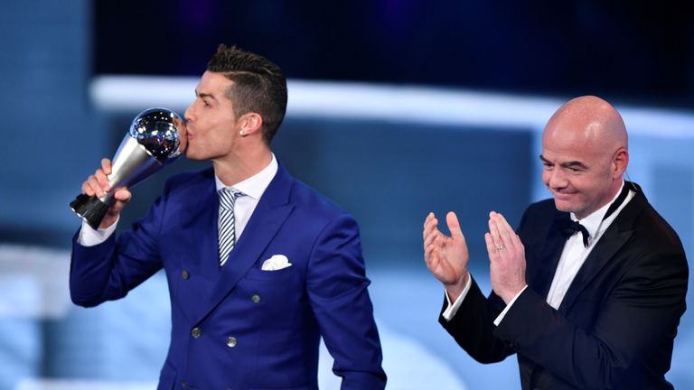 Real Madrid and Portugal's forward Cristiano Ronaldo (L) kisses his trophy after winning the The Best FIFA Mens Player of 2016 Award next to FIFA president