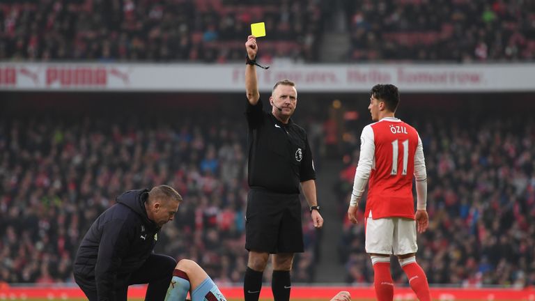 LONDON, ENGLAND - JANUARY 22:  Dean Marney of Burnley is shown a yellow card by referee Jonathan Moss while receiving medical treatment during the Premier 