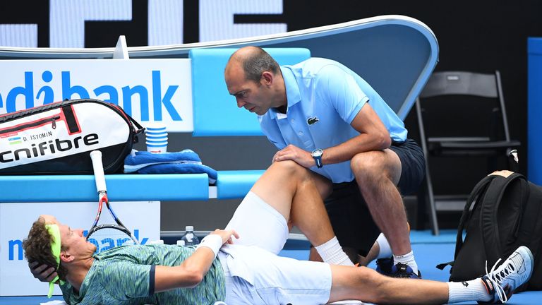 Denis Istomin of Uzbekistan receives medical attention in his fourth round match against Grigor Dimitrov of Bulgaria on