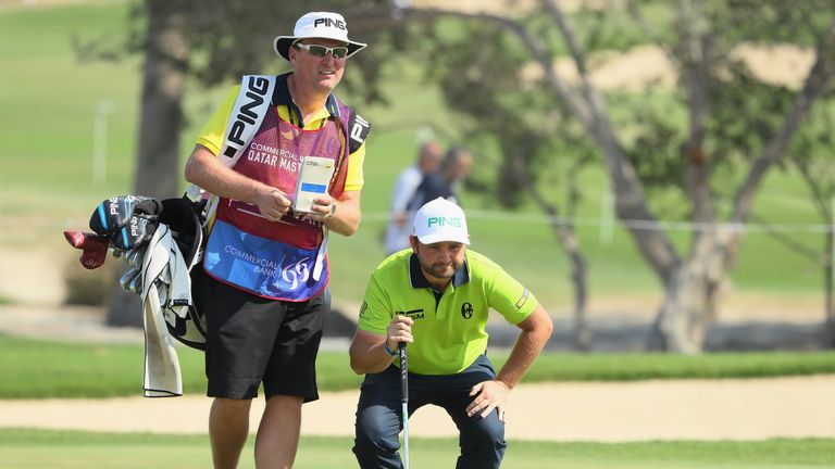 DOHA, QATAR - JANUARY 27:  Andy Sullivan of England lines up a putt with assistance from his caddie Sean McDonagh during the second round of the Commercial