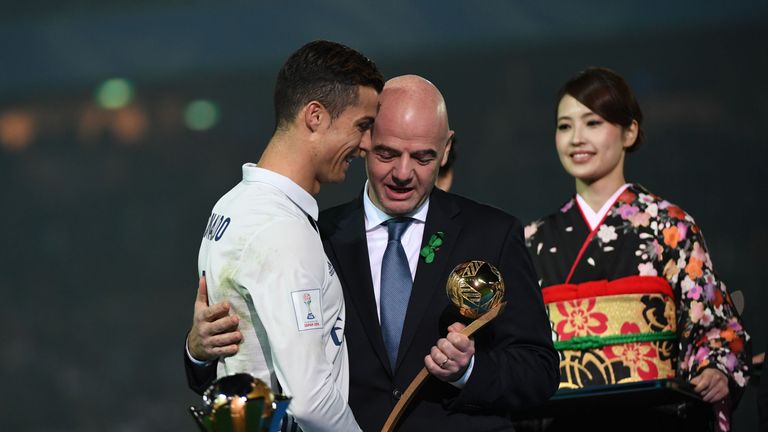 FIFA president Gianni Infantino (C) gives the Golden Ball trophy to Real Madrid's forward Cristiano Ronaldo (L) after the Club World Cup football final mat