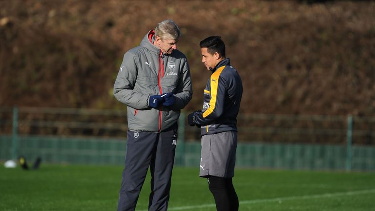 Arsene Wenger chats with Alexis Sanchez during a training session at London Colney