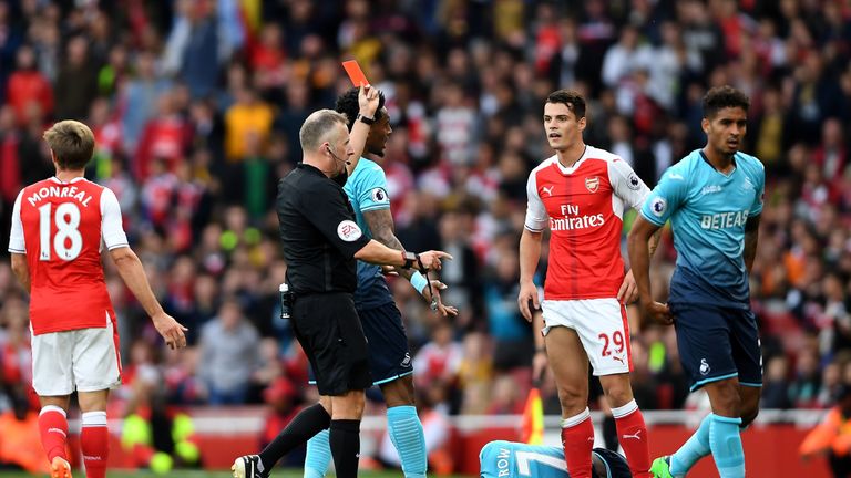 LONDON, ENGLAND - OCTOBER 15:  Referee Jonanthan Moss (L) shows Granit Xhaka of Arsenal (R) a red card during the Premier League match between Arsenal and 