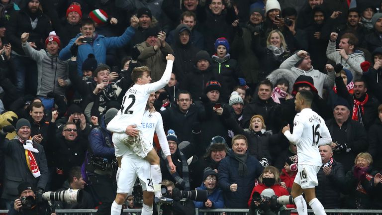 LIVERPOOL, ENGLAND - JANUARY 21: Gylfi Sigurdsson of Swansea City (L) celebrates scoring his sides third goal with Tom Carroll of Swansea City (L) and Wayn
