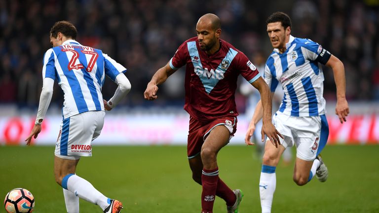 Rigino Cicilia of Port Vale gets past Jon Gorenc Stankovic and Mark Hudson of Huddersfield 