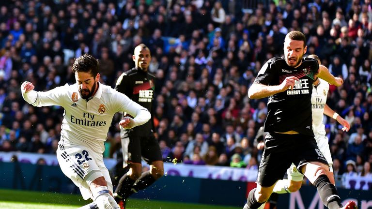 Real Madrid's midfielder Isco (L) kicks the ball to score during the Spanish league football match Real Madrid CF vs Granada FC at the Santiago Bernabeu st