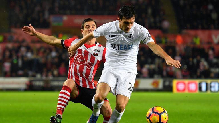 SWANSEA, WALES - JANUARY 31:  Jack Cork of Swansea City controls the ball under pressure of Cedric Soares of Southampton  during the Premier League match b