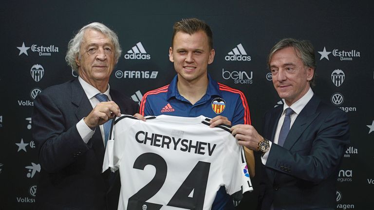 Valencia's new Russian player Denis Cheryshev (C) holds a t-shirt between former Valencia's player (L) Juan Cruz Sol and Valencia general manager Garcia Pi