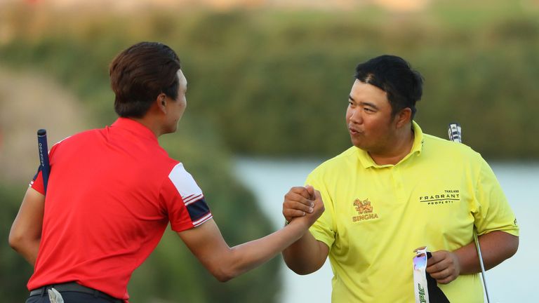 DOHA, QATAR - JANUARY 27:  (L-R) Jeunghun Wang of South Korea and Kiradech Aphibarnrat of Thailand shake hands on the 18th green during the second round of