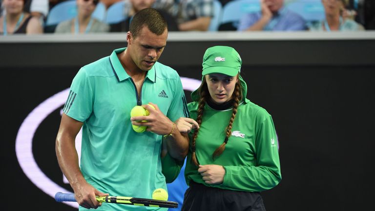 Jo-Wilfried Tsonga escorts an unwell ball girl from the court during his singles match against Omar Jasika at the 2016 Australian Open