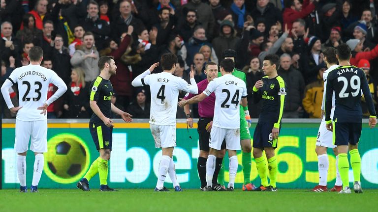 Ki Sung-Yueng of Swansea City is shown a yellow card by referee Mike Jones 