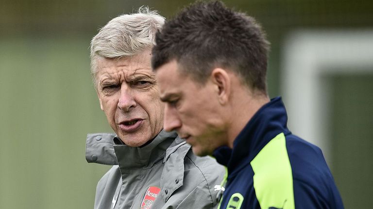 Arsenal's French manager Arsene Wenger (L) talks with Arsenal's French defender Laurent Koscielny during a team training session 
