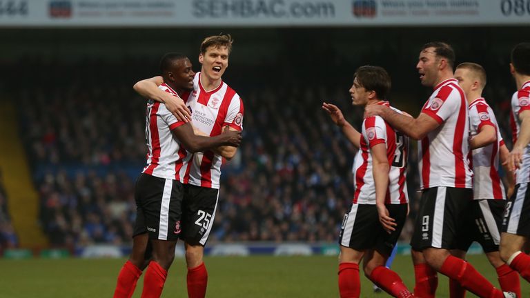 Theo Robinson of Lincoln City celebrates with Sean Raggett after scoring against Ipswich in the FA Cup