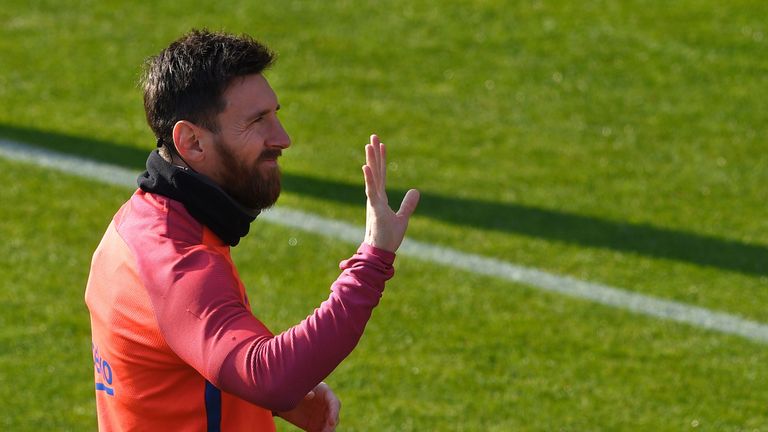 Lionel Messi waves to fans during the training session