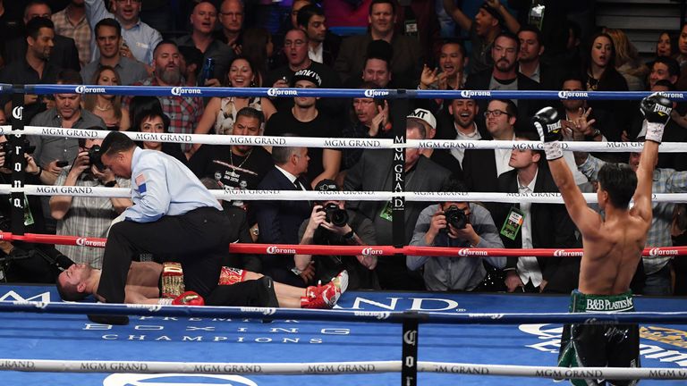 Referee Tony Weeks checks on Dejan Zlaticanin after he was knocked out by Mikey Garcia (R) in the third round