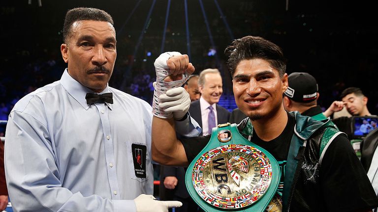 Mikey Garcia (R) poses with referee Tony Weeks after knocking out Dejan Zlaticanin in the third round to win the WBC lightweight