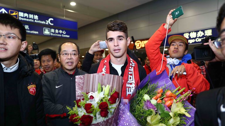 Brazilian football player Oscar (C) is escorted as he arrives at Shanghai airport on January 2 2017