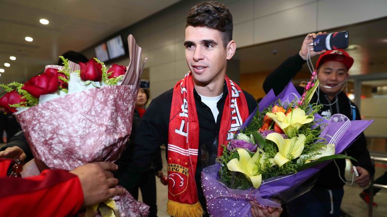 Brazilian football player Oscar (C) receives flowers as he arrives at Shanghai airport on January 2, 2017.  
Brazilian midfielder Oscar landed in Shanghai 
