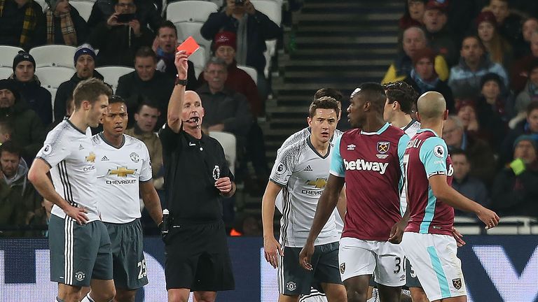 Sofiane Feghouli is shown a red card by referee Mike Dean for his foul on Phil Jones